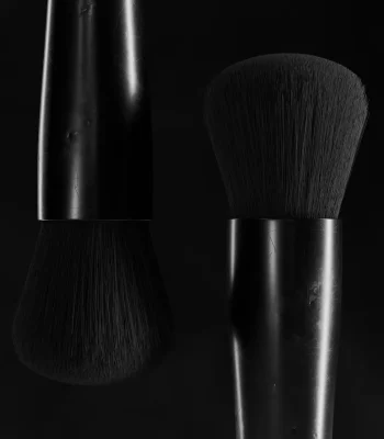 The Heads of cosmetic brushes displayed in a dark environment